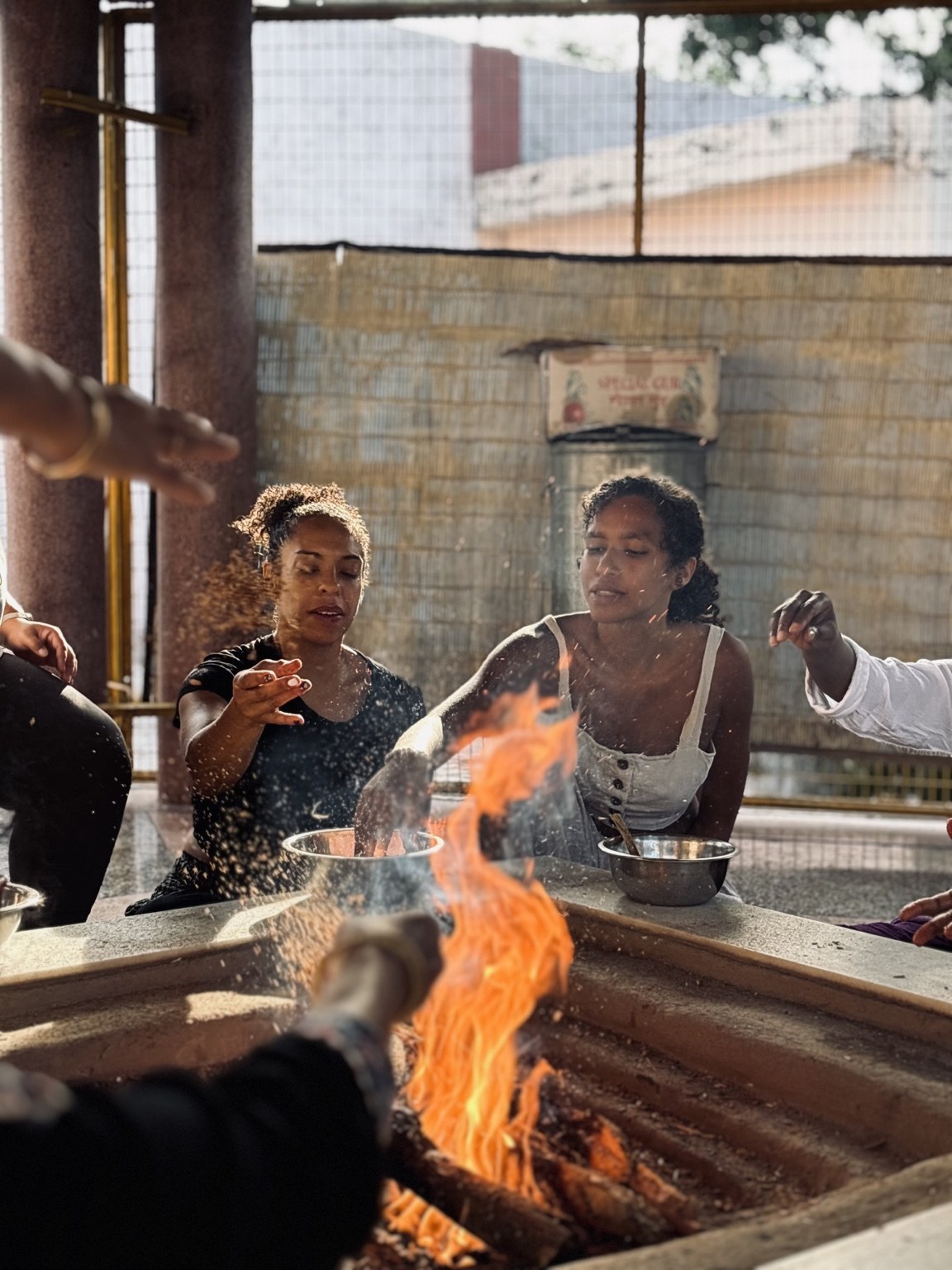 Participants gathered around a ceremonial fire with bowls in front of them